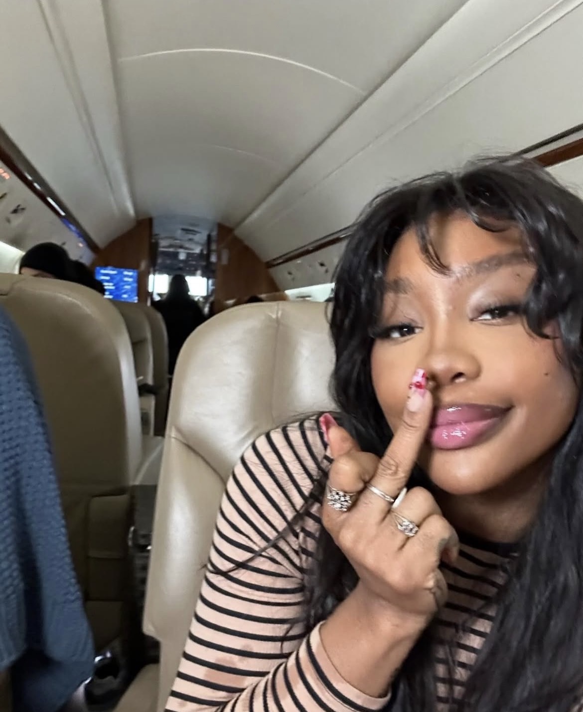 SZA giving the middle finger to the camera with a neutral expression.